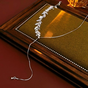 Detail of silver sequin tassel necklace with adjustable snake chain on vintage backdrop