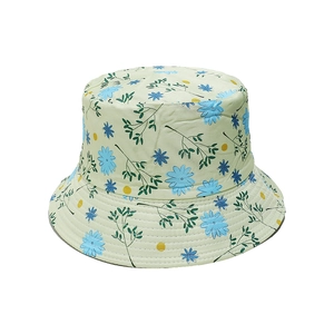 Detail of floral bucket hat with light green base and blue flower prints for summer