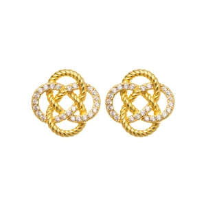 Élégantes boucles d'oreilles nœud dorées avec zircons sur un fond blanc pur