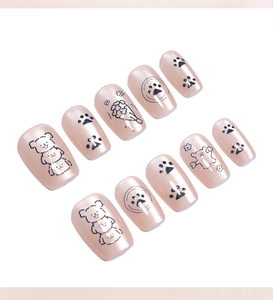Detail of nude pink cat-eye press-on nails with cute cartoon puppy and paw patterns