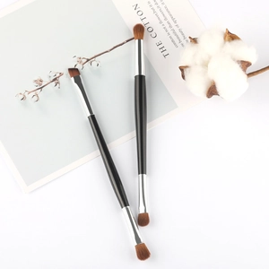 Close-up of double-ended eyeshadow and eyebrow brushes with soft fiber bristles