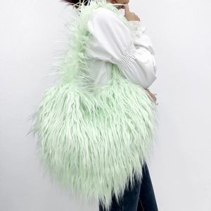 Macro view of light green faux fur shoulder bag with soft plush texture on white background