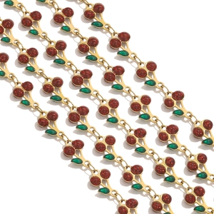 Close-up of red enamel cherry charms with green leaves on a gold stainless steel chain