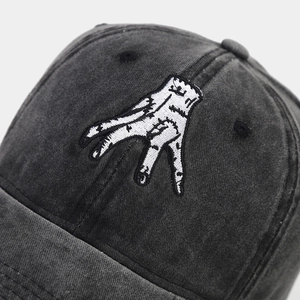 Détail macro de la broderie à la main sur le tissu en coton gris délavé de la casquette
