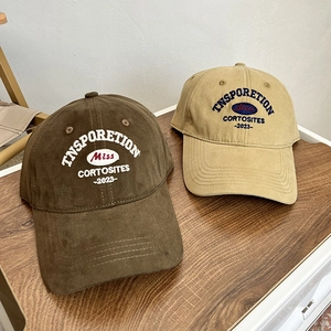 Close-up of vintage embroidered baseball caps in brown and khaki with a classic curved brim