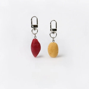 Close-up of handmade resin sweet potato and potato vegetable charms with metal lobster clasps