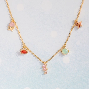 Detail of gold necklace featuring colorful zircon octopus, crab, seahorse, turtle and starfish