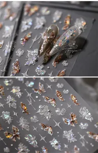 Macro detail of 3D butterfly nail art stickers with iridescent sequins and white pearls