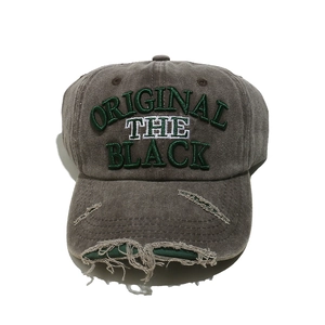 Detailed close-up of distressed baseball cap fabric with 3D embroidery and frayed holes