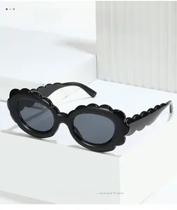 Close-up of stylish black sunglasses featuring unique scalloped wavy frame edges