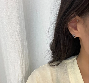 Close-up of 925 sterling silver bow hoop earring on model with soft lighting