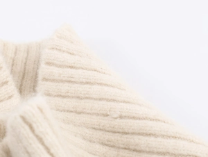 Gros plan sur le tissu en laine tricotée côtelée de couleur crème et sa texture douce