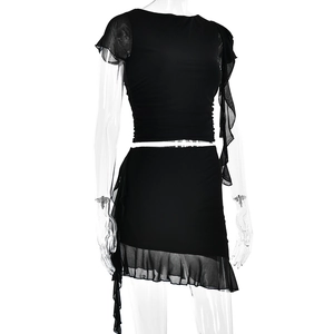 Close-up of black mesh ruffle sleeves and pleated detail on the cropped top of a two-piece set