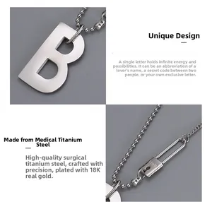 Gros plan du collier avec pendentif B en acier titane et fermoir épingle à nourrice gravé