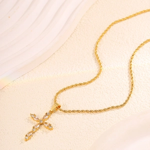 Close-up of gold stainless steel cross necklace with crystal pavé on twisted chain