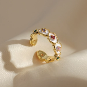 Chic gold-tone open flower ring with colorful floral enamel on beige fabric