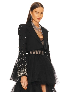 Detail of beaded blazer sleeve with silver studs and layered mesh tulle dress