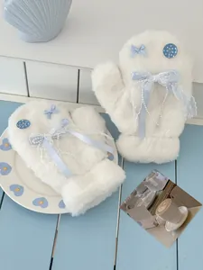 Detailed shot of plush white mittens featuring blue bows, pearls and lace accents