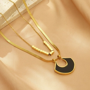 Double-layered gold necklace with black geometric pendant and flat snake chain design