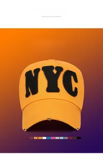 Close-up of yellow NYC baseball cap showing black embroidery and distressed brim details