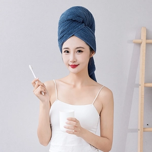 Deep blue waffle texture hair towel wrap shown on model in a soft lit indoor bathroom setting
