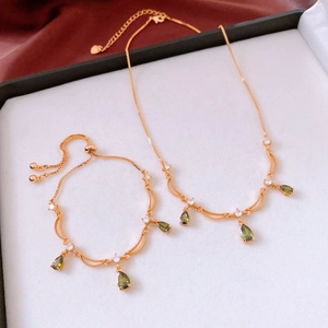 Nahaufnahme des 18k vergoldeten Schmucksets mit olivgrünen Tropfensteinen und Kristallen