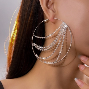 Silver-plated oversized hoop earrings with shimmering rhinestone tassels on model