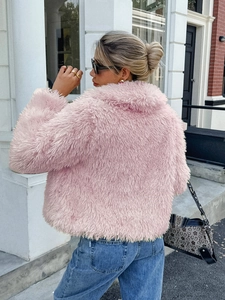 Detail of pink faux fur jacket texture and stylish street wear look with city backdrop