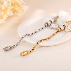 Détail de bracelets en acier titane avec perles et fermoir magnétique en coloris or et argent