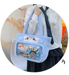 Detail of light blue penguin plush tote bag with clear PVC window for anime badges