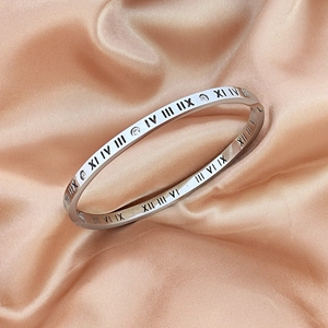 Silver Roman numeral bangle with zircon inlay on luxury champagne satin background