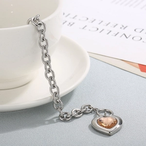 Detail of silver OT buckle bracelet featuring champagne heart crystal on a white cup