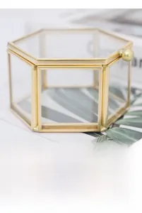 Detail shot of hexagonal glass jewelry box with gold brass frame and ball handle