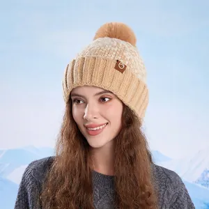 Women's knit pom-pom beanie with fleece lining in cream and khaki patchwork design