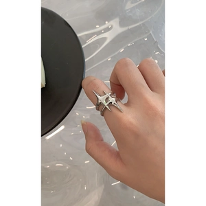 Detailed view of silver star-shaped open ring featuring polished geometric metal spikes
