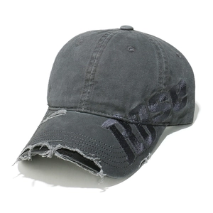 Close-up of distressed vintage baseball cap with frayed holes and RISE embroidery detail