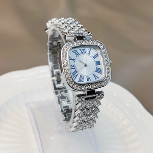 Macro shot of silver square watch face with sparkling rhinestones and Roman numerals