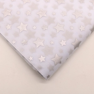 Detail showing white tissue paper with silver star patterns for flower wrapping
