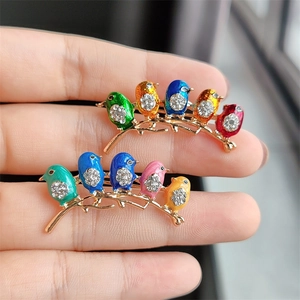 Colorful enamel bird brooch with sparkling rhinestones and gold plating on metal base