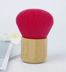 Macro detail of soft round pink bristles and natural bamboo handle on a makeup brush