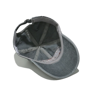 Detail of grey washed cotton baseball cap with adjustable metal buckle and inner stitching
