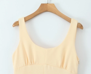 Détail de la robe sans manches jaune pâle élégante avec tissu lisse et fermeture éclair