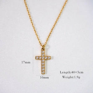 Detail view of gold cross pendant necklace with clear zircon and dimensions display