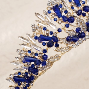 Macro shot of gold bridal crown featuring intricate blue and clear crystal detailing