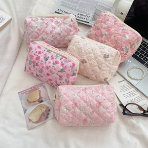 Detailed view of quilted floral pouches with cherry and bunny prints in soft cotton
