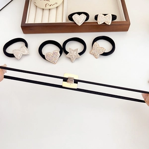 Elastic rhinestone hair ties with heart and butterfly charms on a white surface