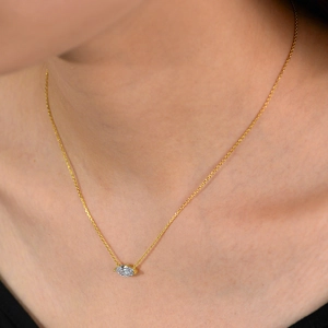 Close-up of elegant gold s925 silver necklace with marquise zircon pendant on a model