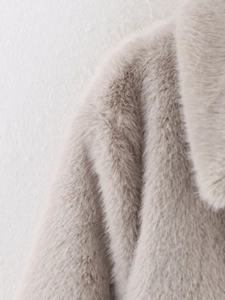 Detailed close-up of faux fur collar and shoulder texture on a beige short coat