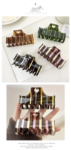 Macro detail of retro striped hair claw clips with heart cutout and glossy finish