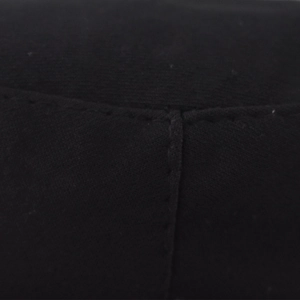 Détail de la couture à double aiguille sur le tissu noir de la casquette militaire
